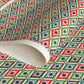 A sheet of katazome paper with a repeat rhombus pattern with the Japanese motif of the water caltrop plant (hishi) depicted alongside the four-petal flower of the water chestnut (hanabishi) in red, green. brown and teal.