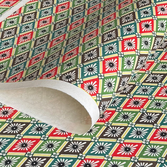 A sheet of katazome paper with a repeat rhombus pattern with the Japanese motif of the water caltrop plant (hishi) depicted alongside the four-petal flower of the water chestnut (hanabishi) in red, green. brown and teal.