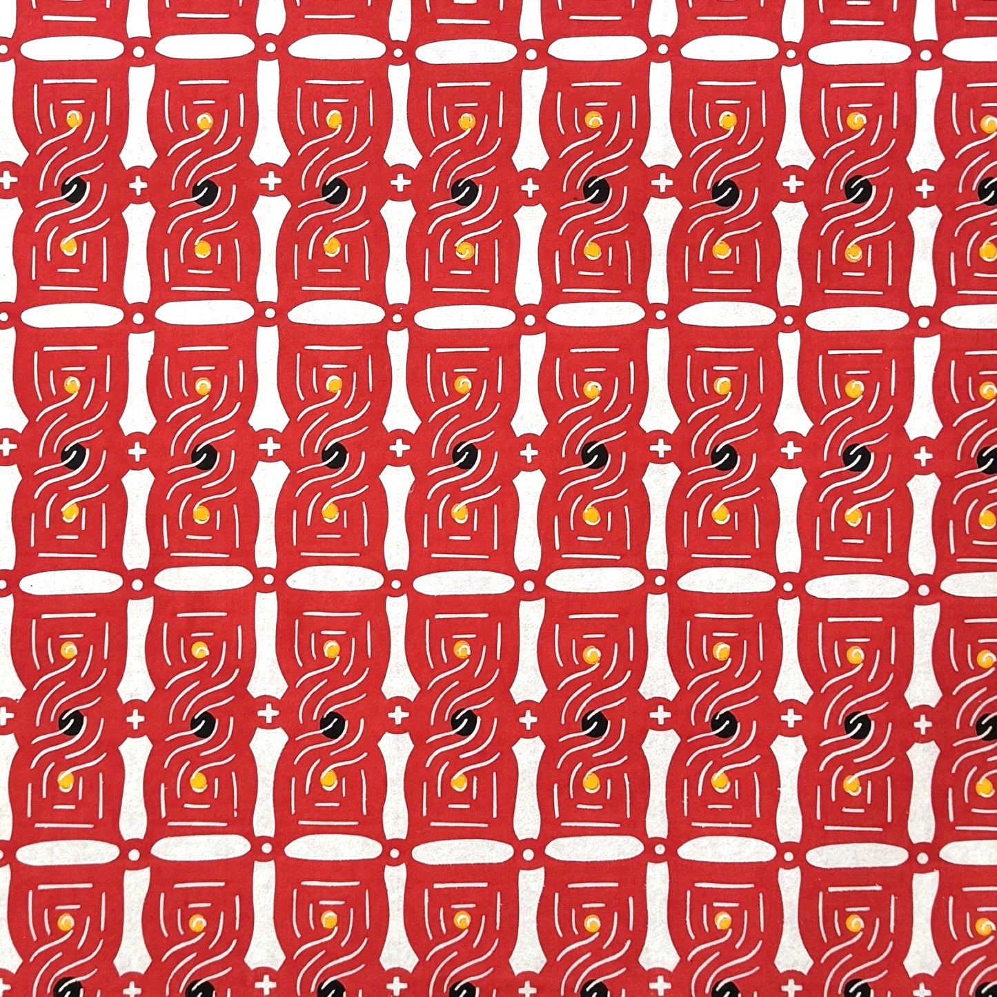 A sheet of katazome paper with a stylised knot design in red on white 