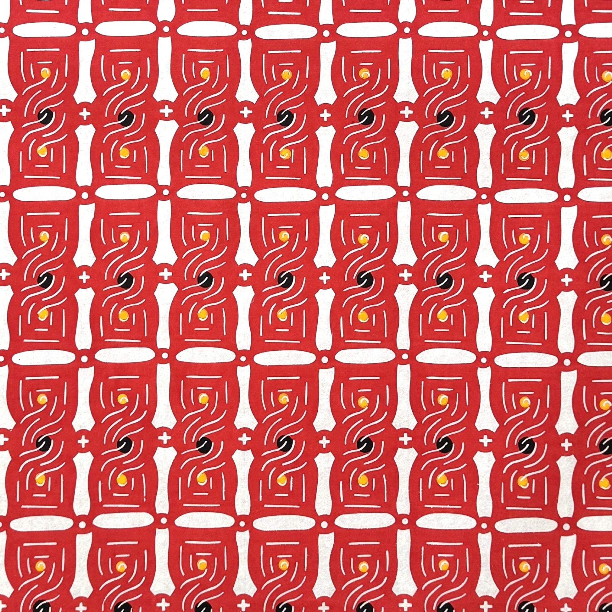 A sheet of katazome paper with a stylised knot design in red on white 