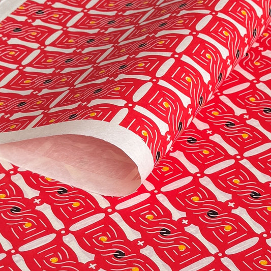 A sheet of katazome paper with a stylised knot design in red on white 