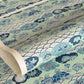 A colourful traditional pattern depicting stylised waves (seigaiha), flowers and foliage in a soft aqua and blue palette. A sheet of katazome paper