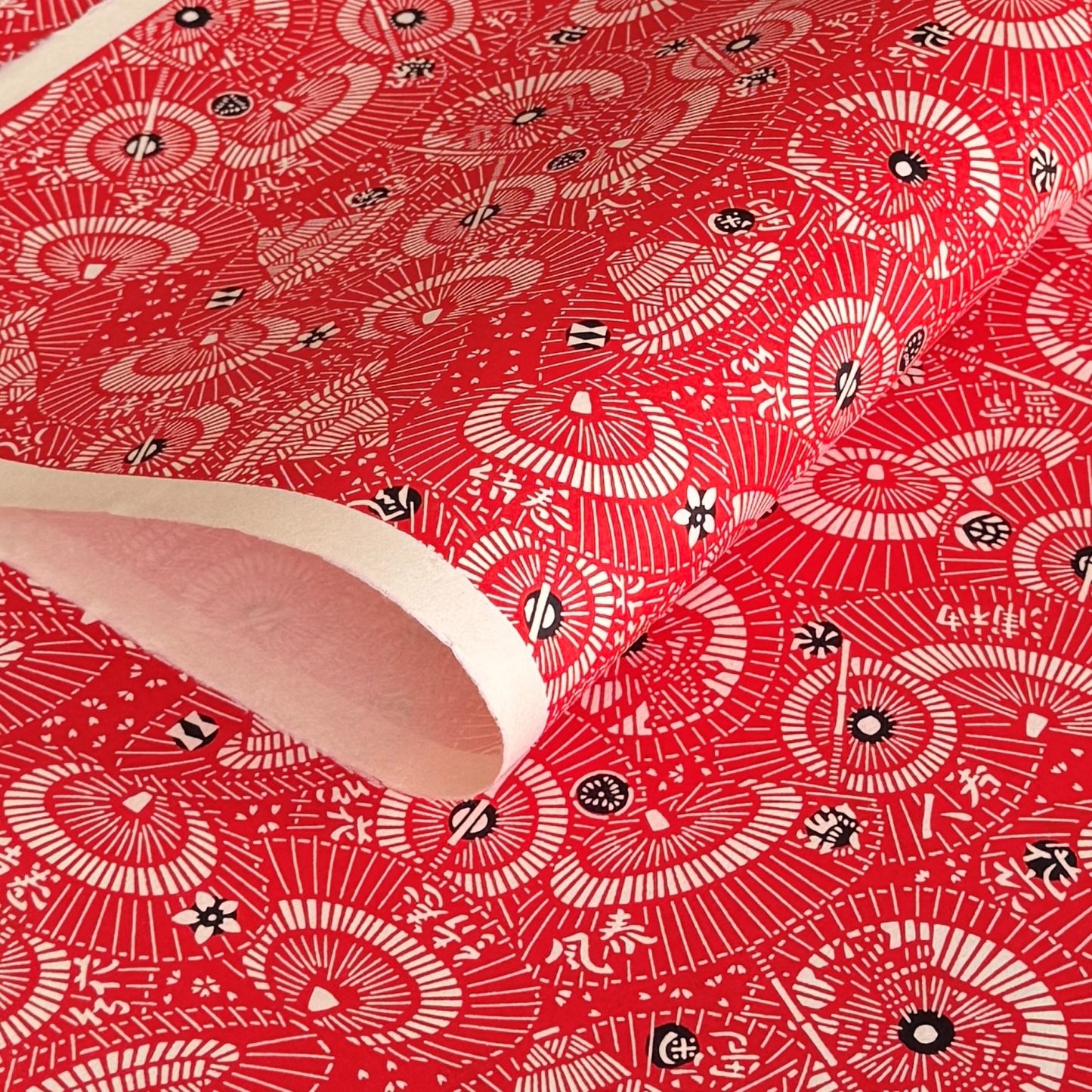 a sheet of Japanese katazome paper with a pattern of red and white umbrellas 