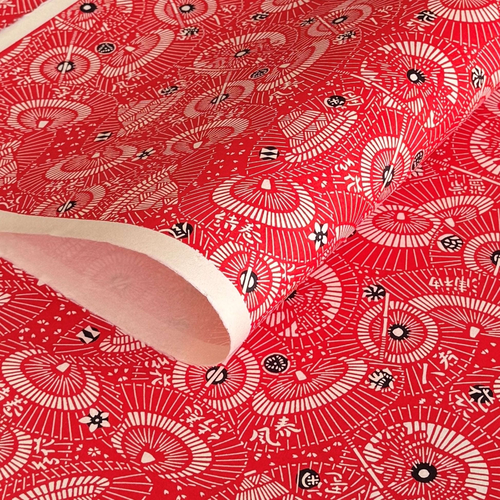 a sheet of Japanese katazome paper with a pattern of red and white umbrellas 