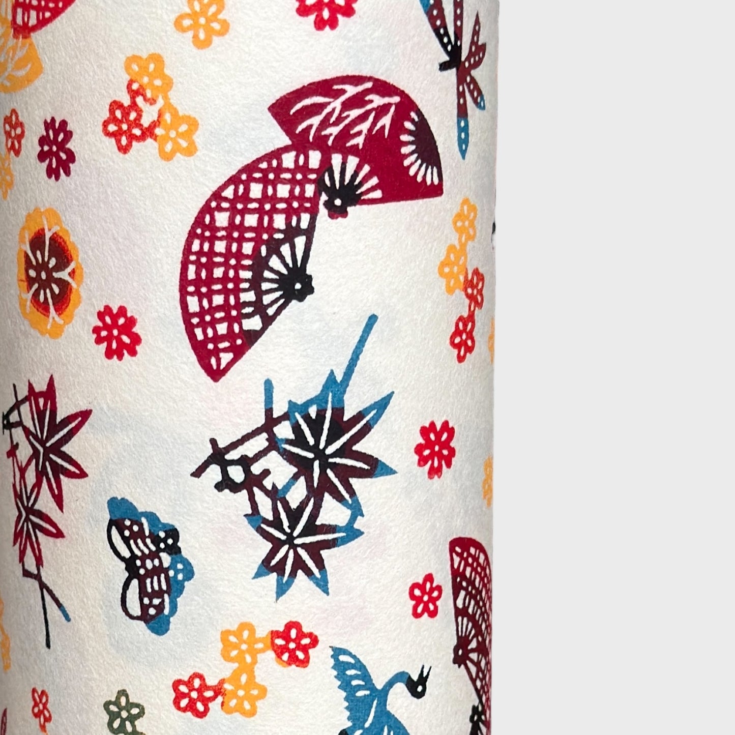 Folding fans (sensu) and cranes (tsuru) amongst flowers and foliage.  A multicoloured pattern on Japanese katazome paper