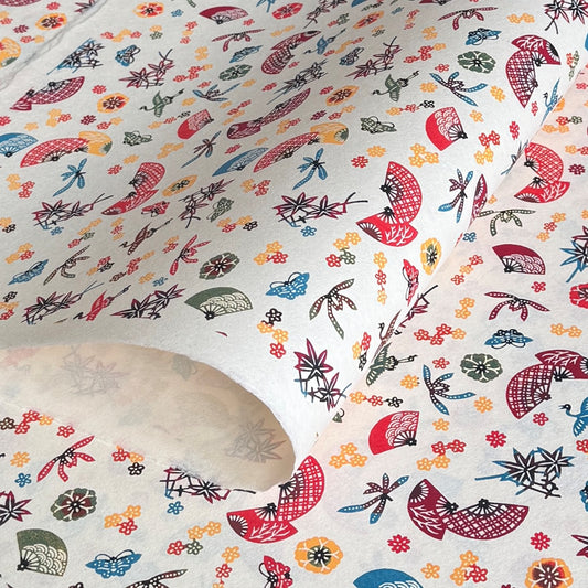 Folding fans (sensu) and cranes (tsuru) amongst flowers and foliage.  A multicoloured pattern on Japanese katazome paper