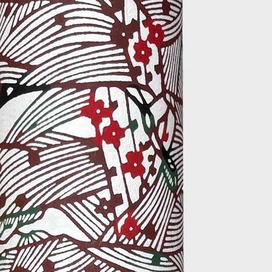 A botanical pattern with bamboo (take) and flowers in brown, red and green. A sheet of katazome paper. Close up