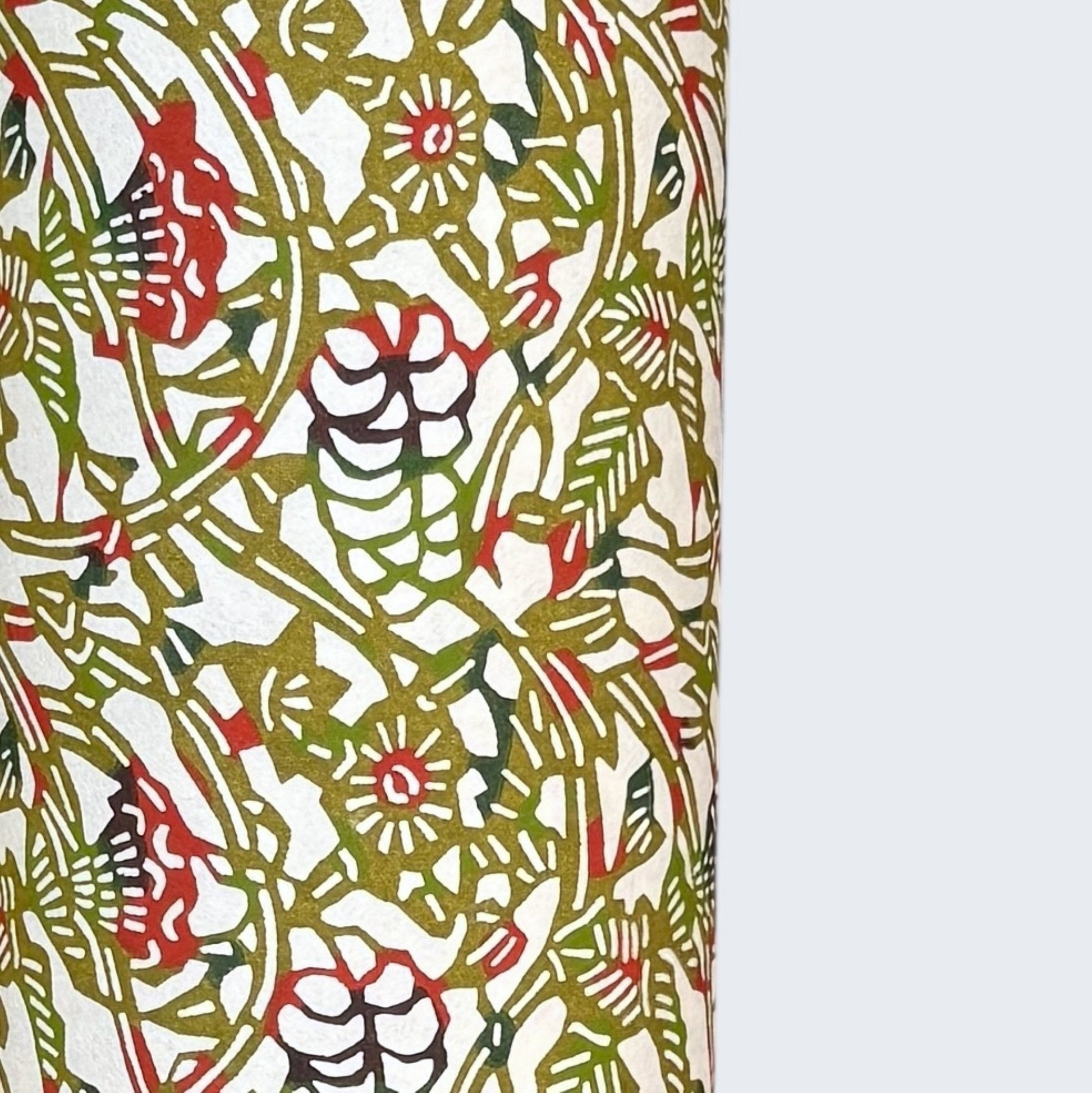 Small botanical pattern in olive green and red.  A sheet of Japanese katazome paper. Close up