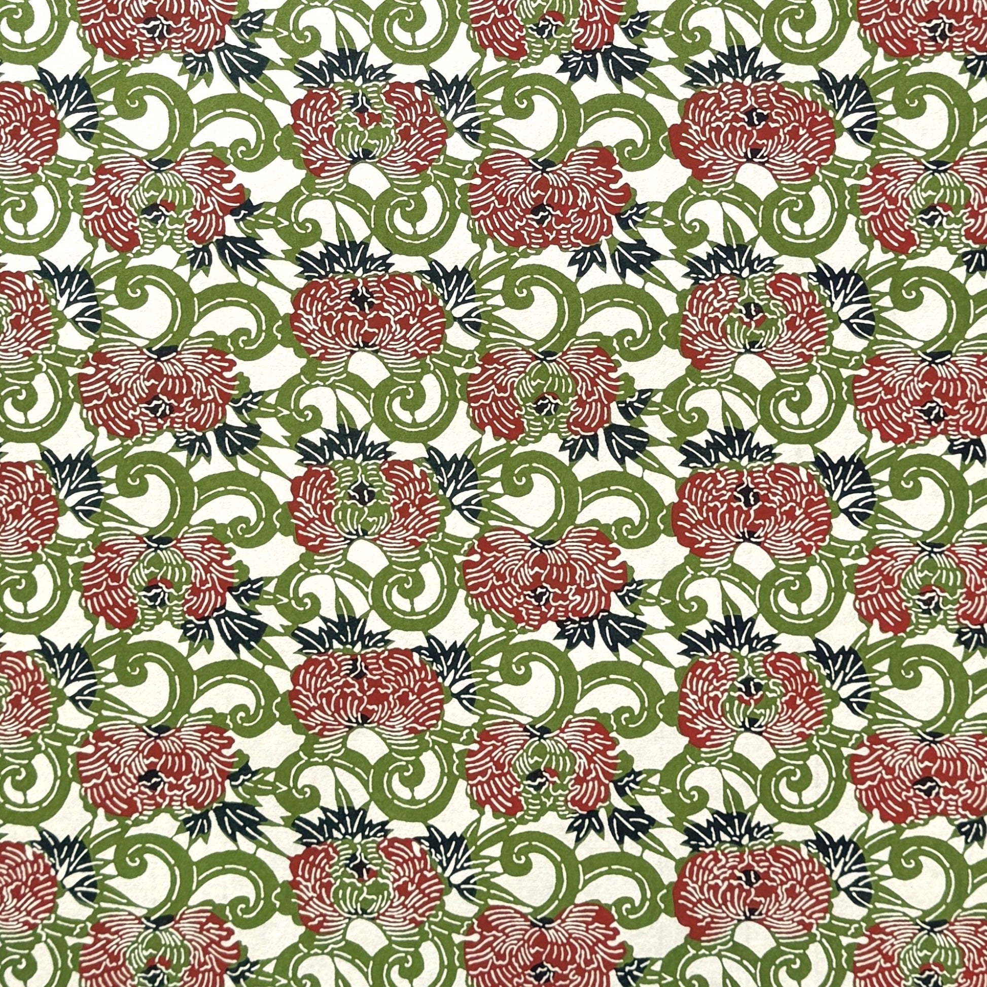 a sheet of katazome paper with a pattern of peonies (botan) in a rich red amongst green foliage
