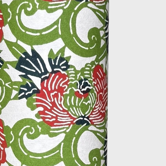 a sheet of katazome paper with a pattern of peonies (botan) in a rich red amongst green foliage. close up