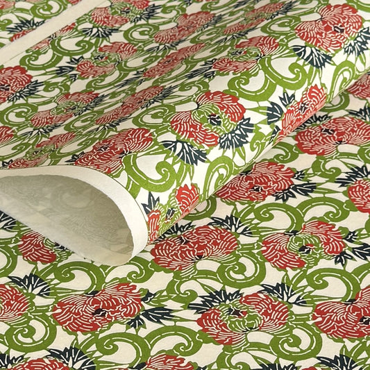 a sheet of katazome paper with a pattern of peonies (botan) in a rich red amongst green foliage