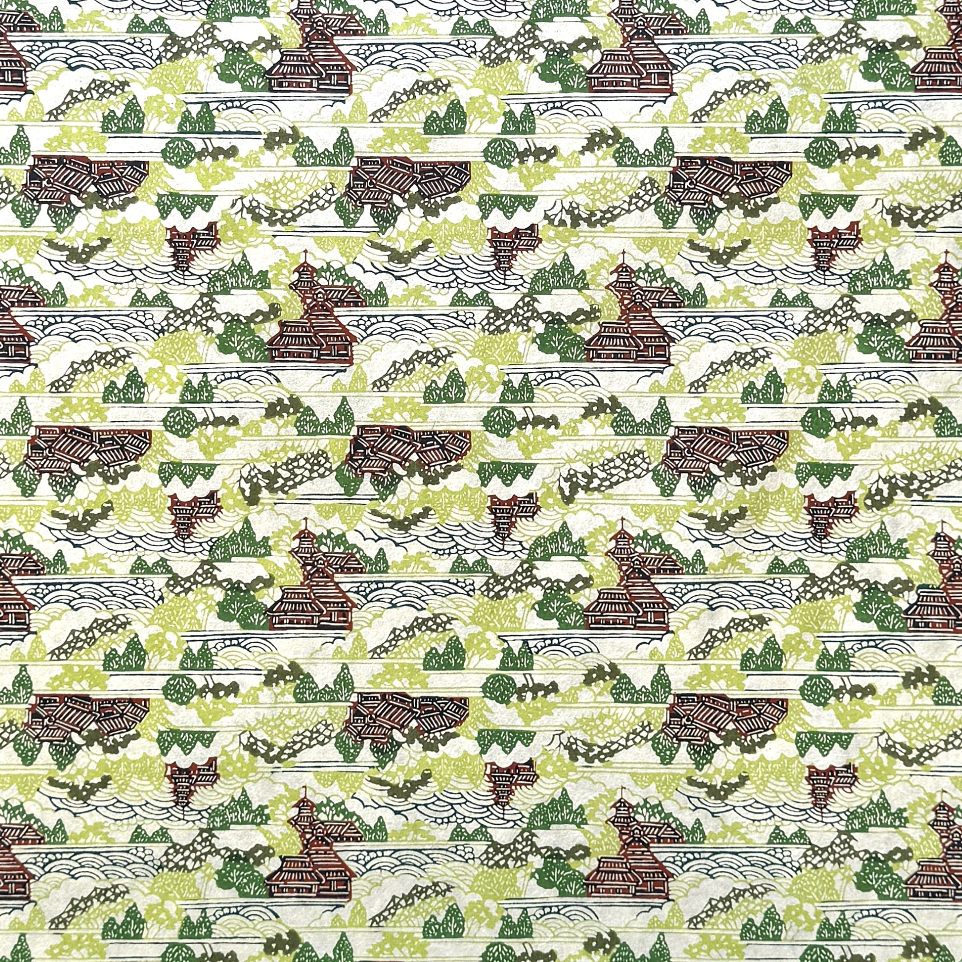 a sheet of katazome paper with a pattern of a hillside village in lime green, green and brown