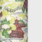 a sheet of katazome paper with a pattern of a hillside village in lime green, green and brown. Close up
