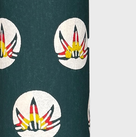 Traditional pattern a Japanese circular crest of a colourful lotus flower on a dark teal.  A shhet of katazome paper. Close up