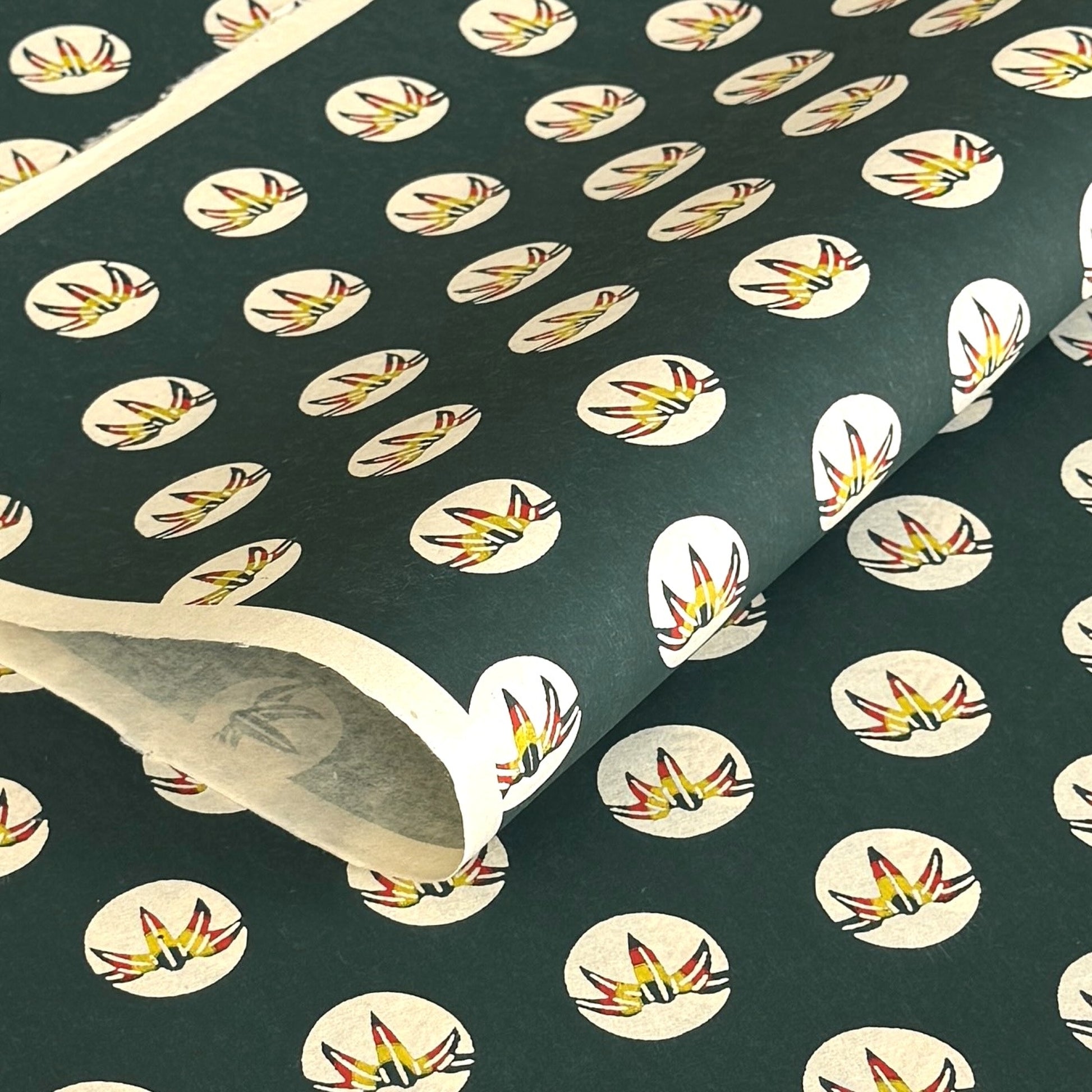 Traditional pattern a Japanese circular crest of a colourful lotus flower on a dark teal.  A sheet of katazome paper