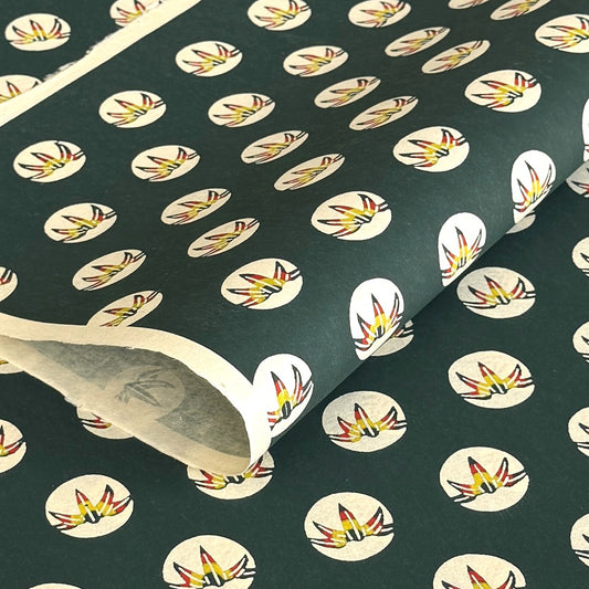 Traditional pattern a Japanese circular crest of a colourful lotus flower on a dark teal.  A sheet of katazome paper