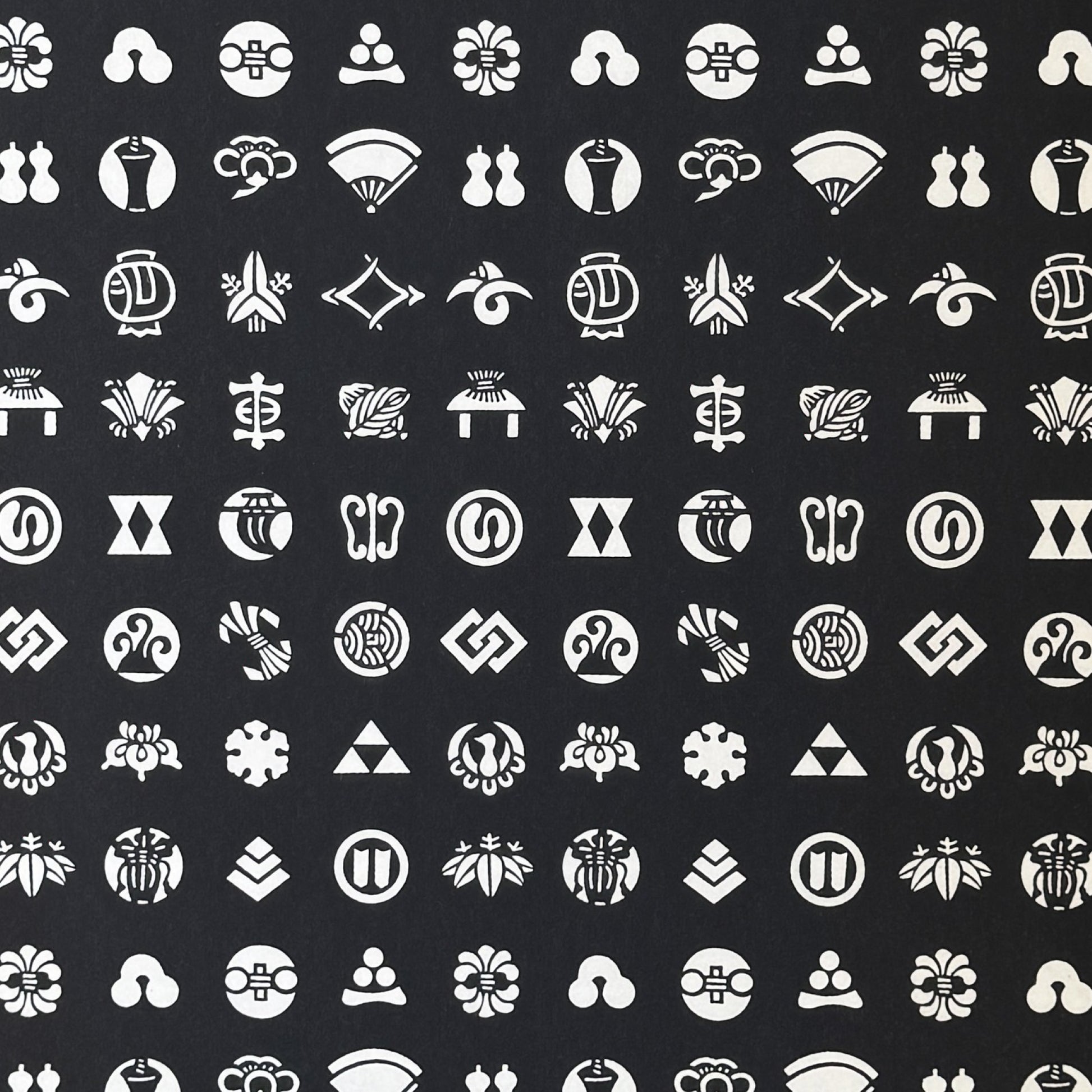 Japanese crests (mon) in monochrome. A sheet of stencil-dyed katazome paper in black with white crest symbols