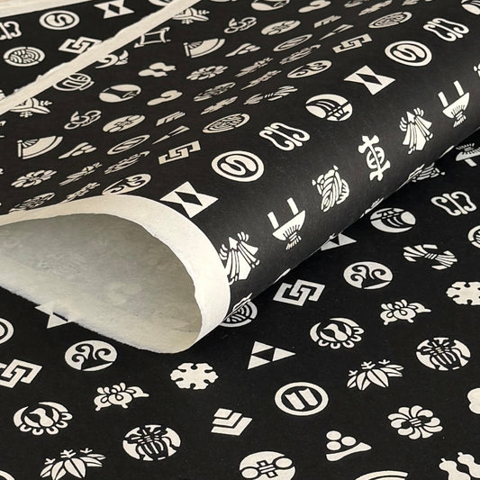 Japanese crests (mon) in monochrome. A sheet of stencil-dyed katazome paper in black with white crest symbols