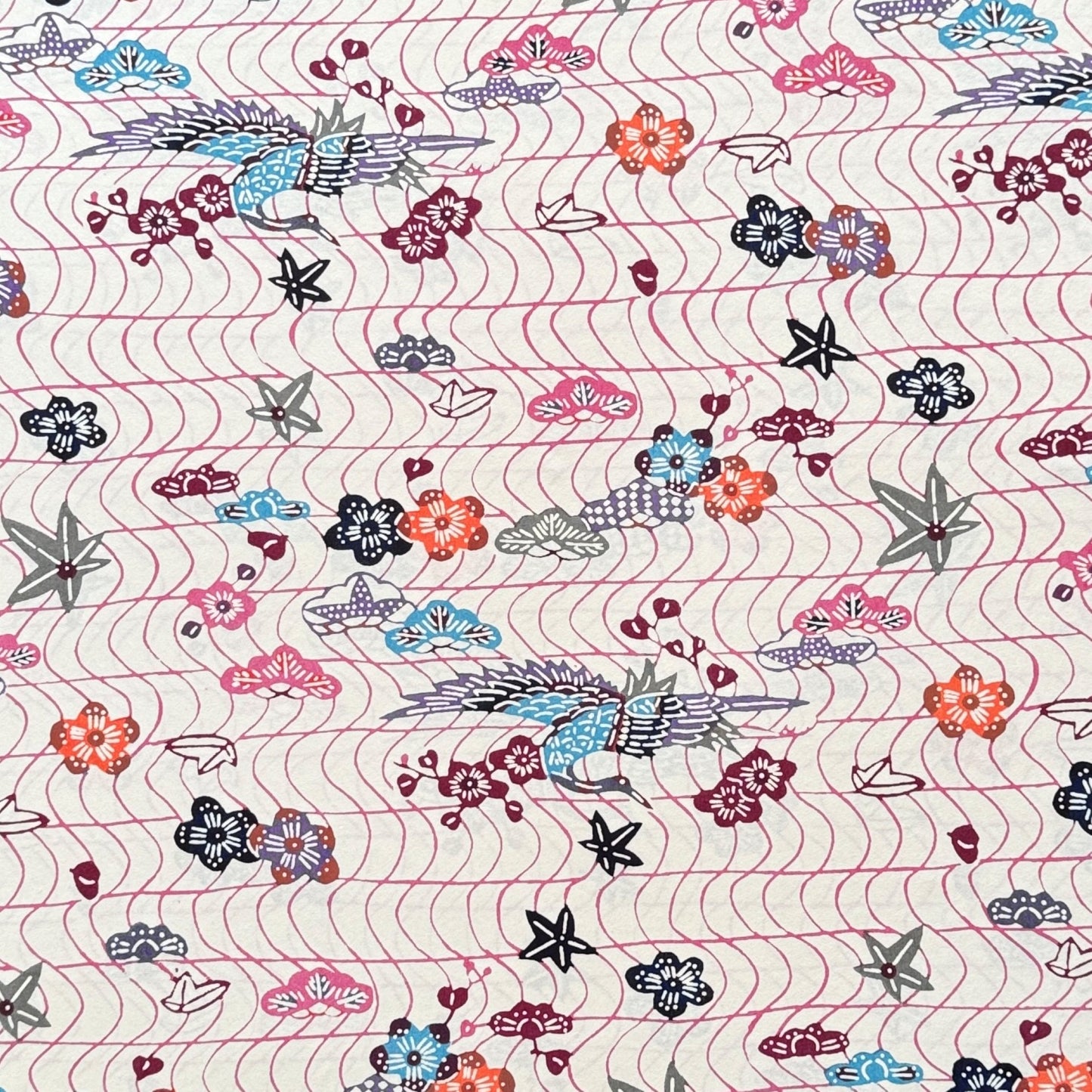 Pattern with cranes and flowers in soft pink, purple, blue and orange.  A sheet of katazome paper