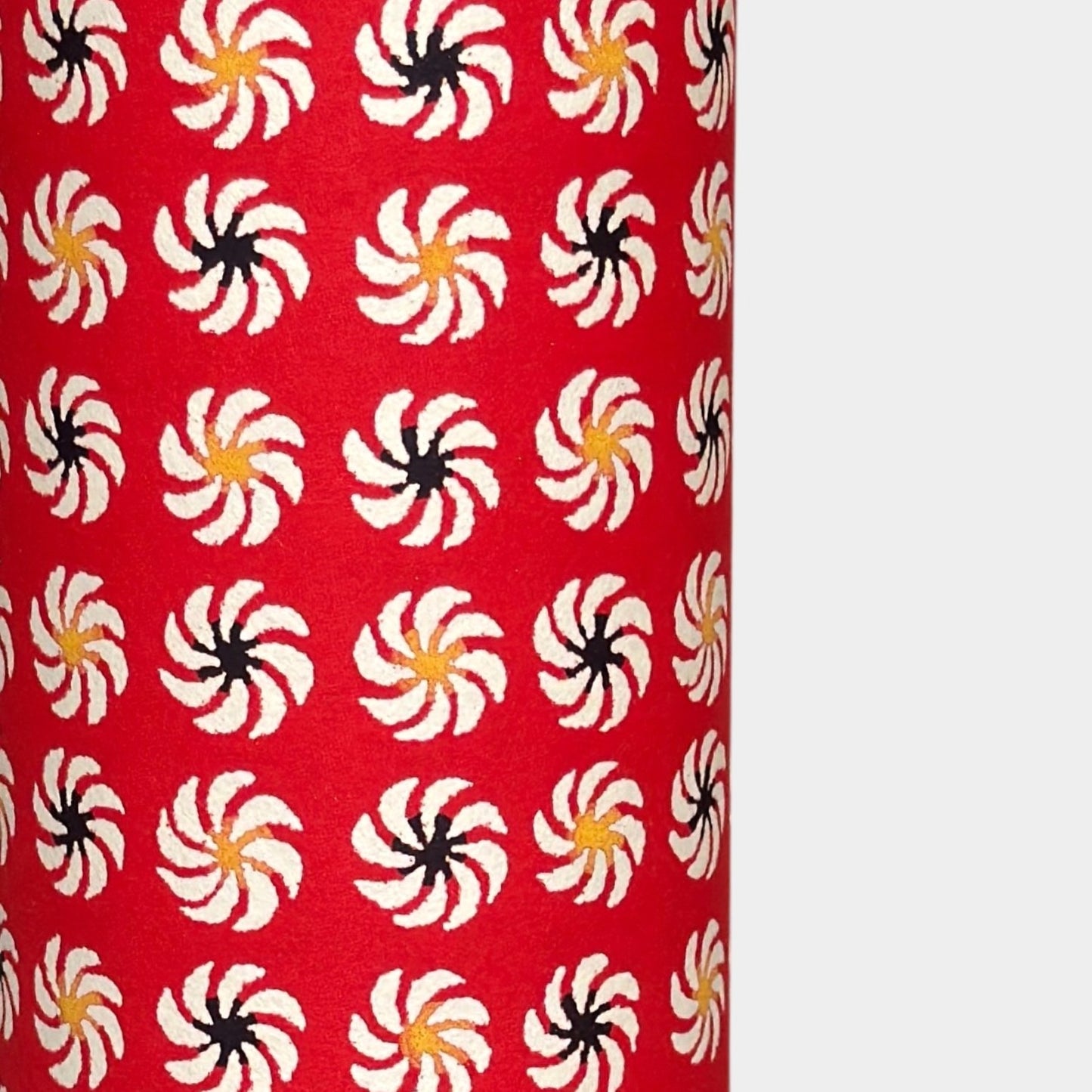 a sheet of Japanese katazome-shi paper with a repeat pattern of circular abstract flowers in white. Close up