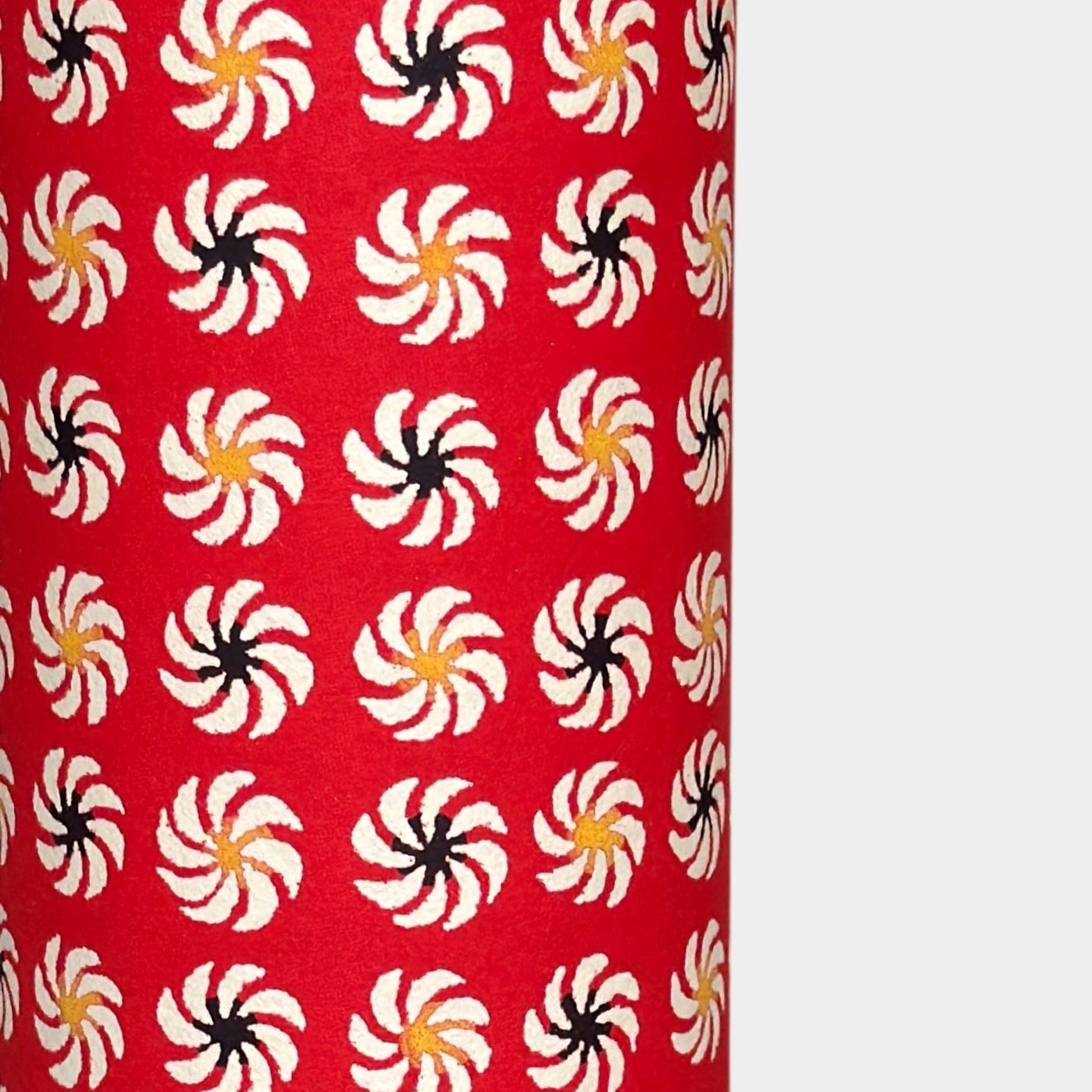 a sheet of Japanese katazome-shi paper with a repeat pattern of circular abstract flowers in white. Close up