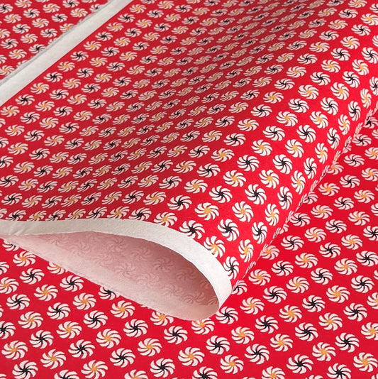 a sheet of Japanese katazome-shi paper with a repeat pattern of circular abstract flowers in white