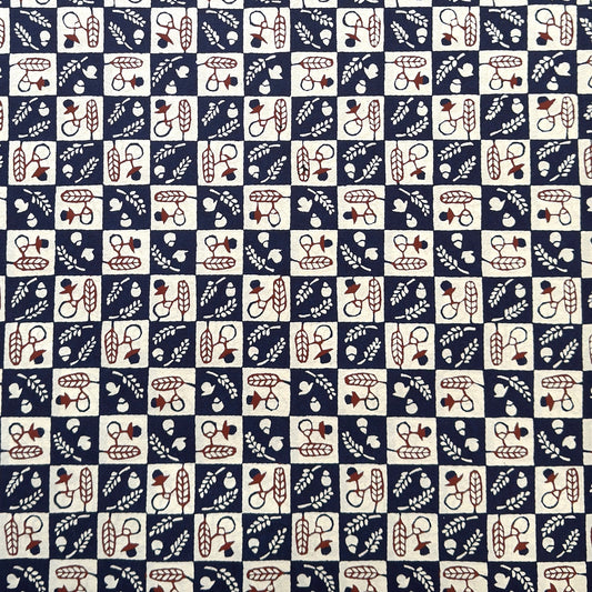 Japanese katazome-shi paper in navy blue and cream chequerboard pattern with motifs of autumn - acorns and wheat.