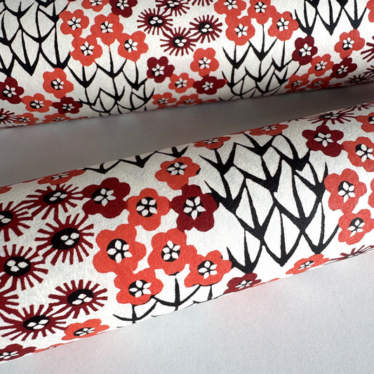 Japanese katazome-shi paper stencil -dyed with a small red flower design, little black stems on ivory paper. Rolled