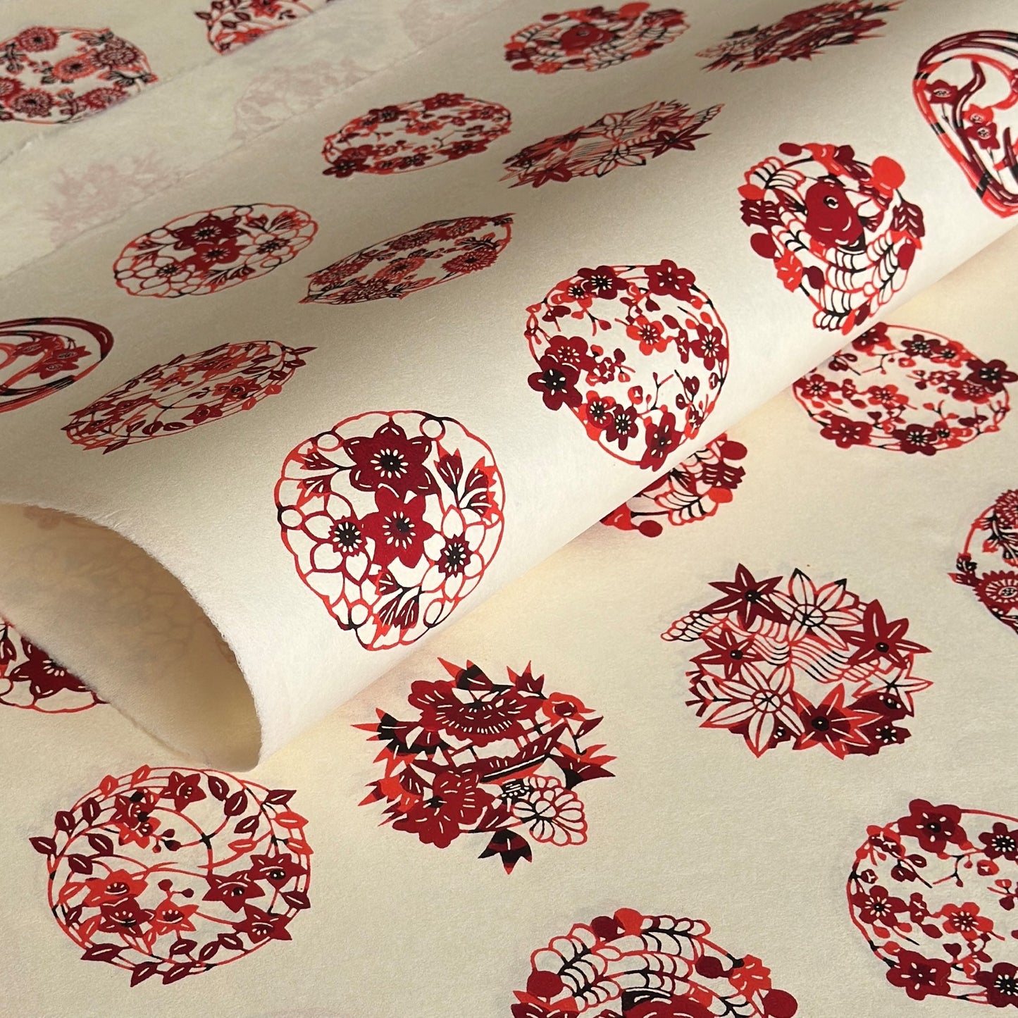 Inky rich red botanical motif circles (maru mon) on plain ivory Jpaanese katazome-shi paper