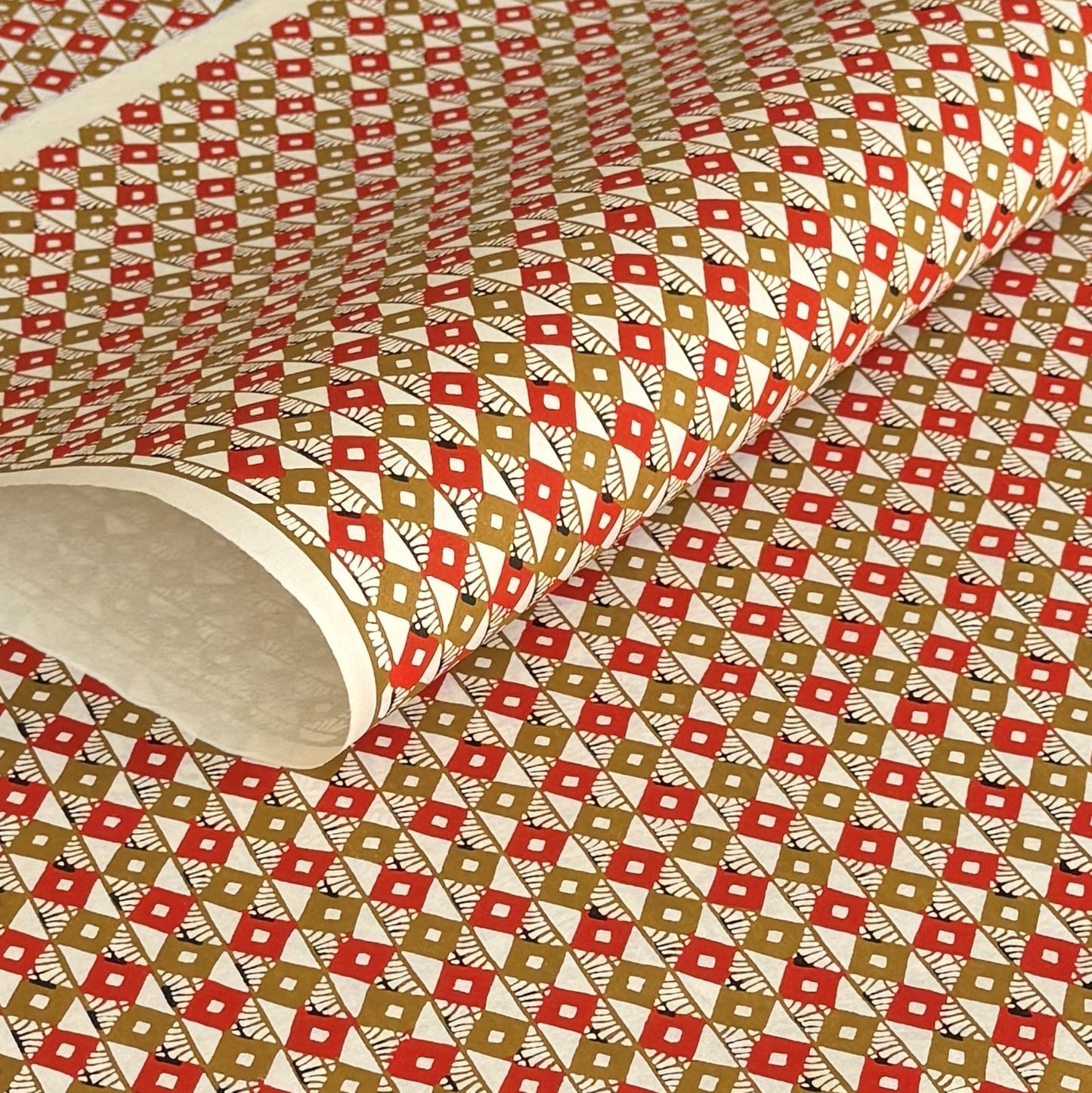 Geometric two-tone brown diamond (kuginuki tsunagi) repeat pattern on a sheet of Japanese katazome paper