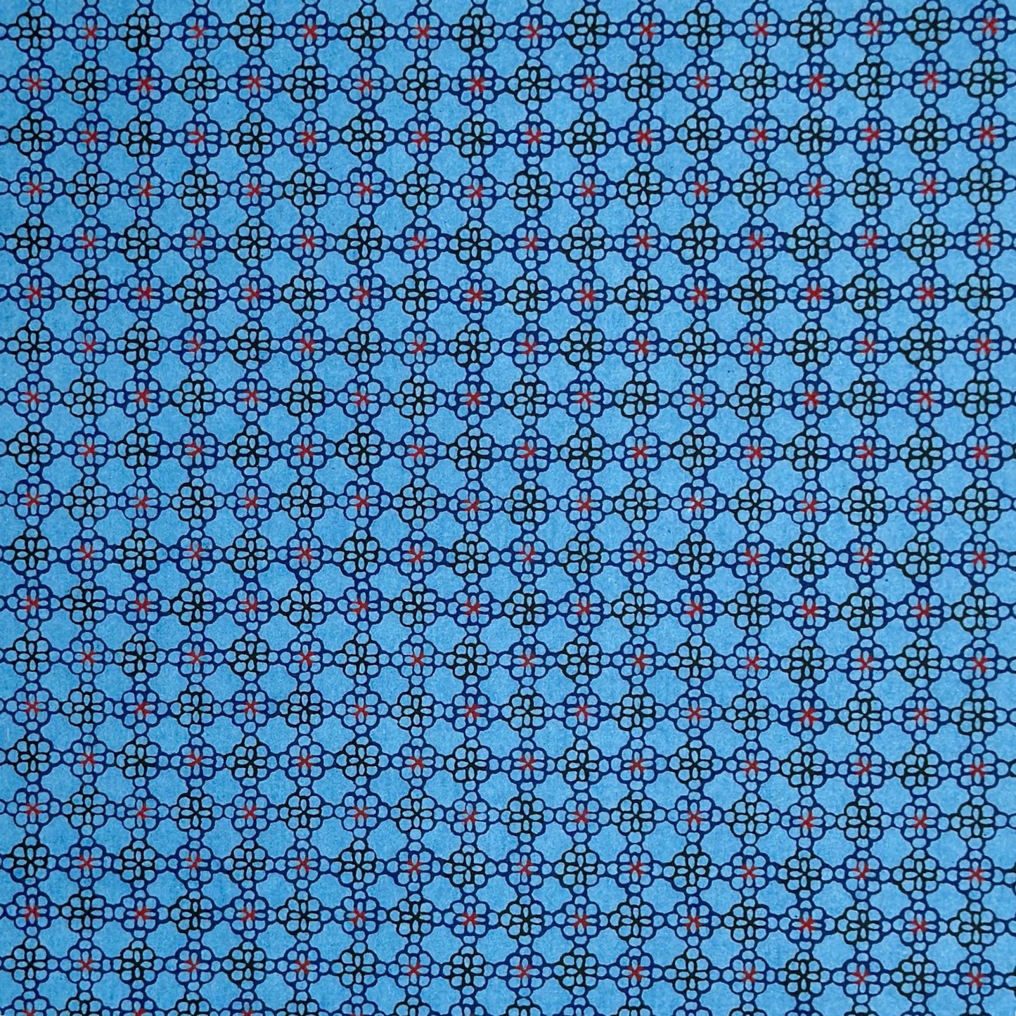 a sheet of Japanese katazome shi paper with a delicate tile repeat pattern on a bright blue backdrop