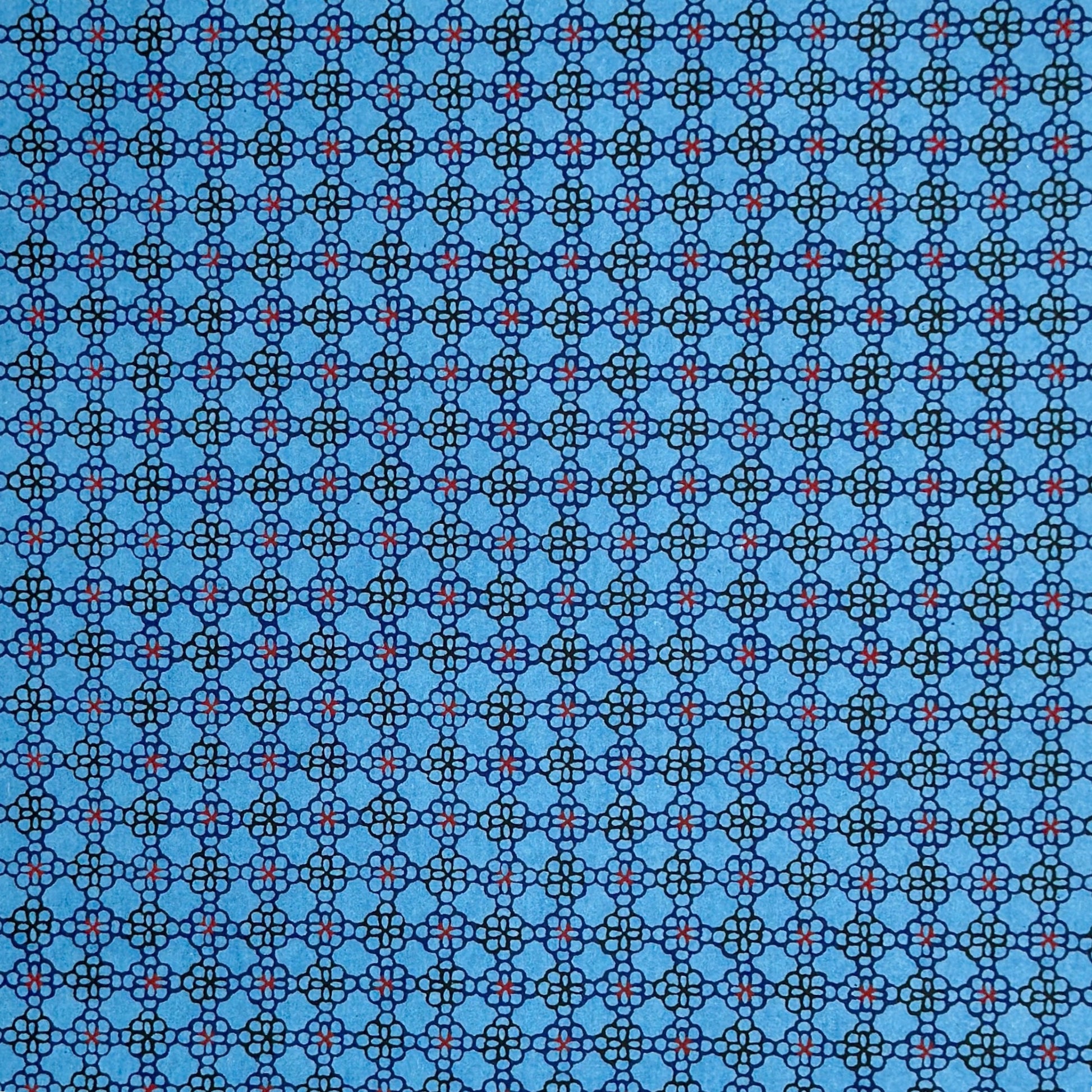 a sheet of Japanese katazome shi paper with a delicate tile repeat pattern on a bright blue backdrop