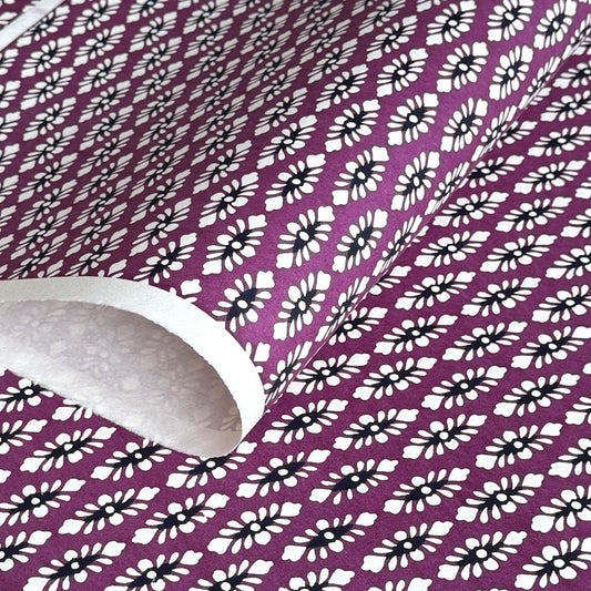 japanese katazome-shi paper (stencil-dyed) with a white and black repeat pattern on purple.