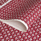 A Japanese stencil-dyed patterned paper with a repeat pattern in white on a deep rich red background.