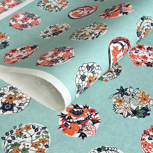 japanese stencil-dyed handmade paper with traditional botanical circles pattern on aqua backdrop
