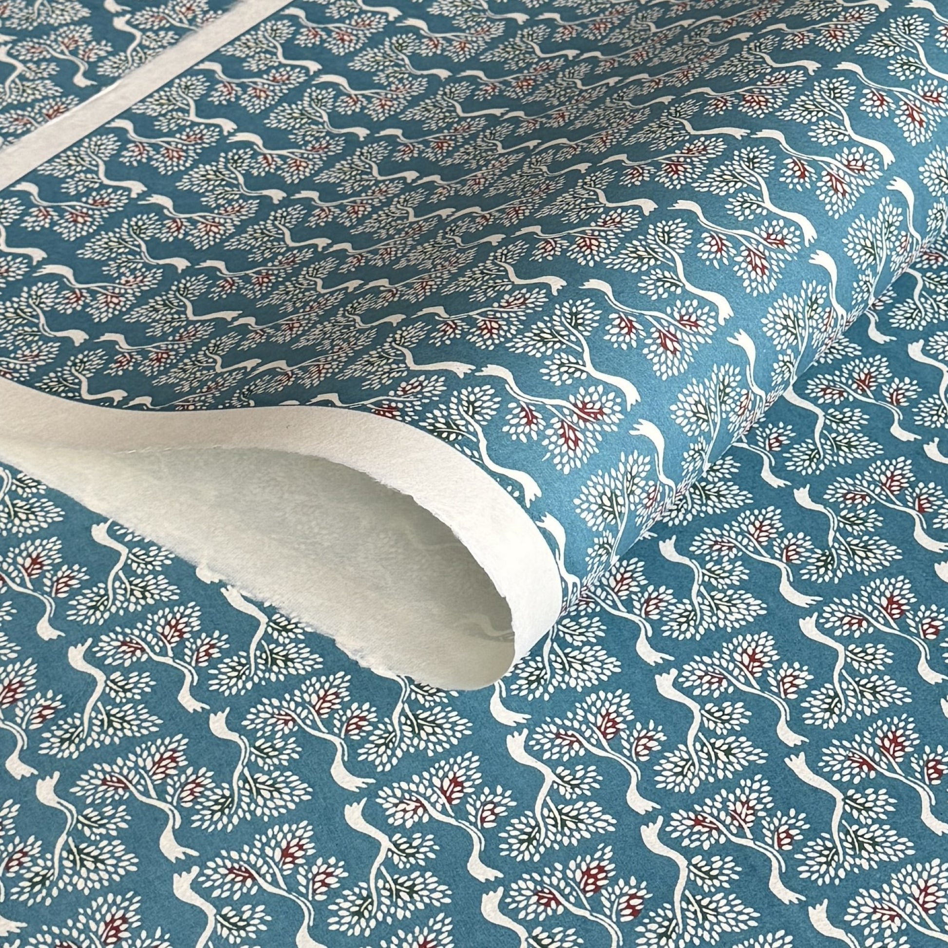 japanese stencil-dyed handmade paper with bonsai tree repeat pattern on blue backdrop
