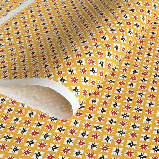 japanese stencil-dyed handmade paper with small scale floral repeat pattern on yellow backdrop