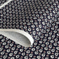 japanese stencil-dyed paper with a white swirl geometric repeat pattern on a dark inky blue background