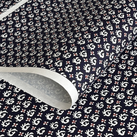 japanese stencil-dyed paper with a white swirl geometric repeat pattern on a dark inky blue background