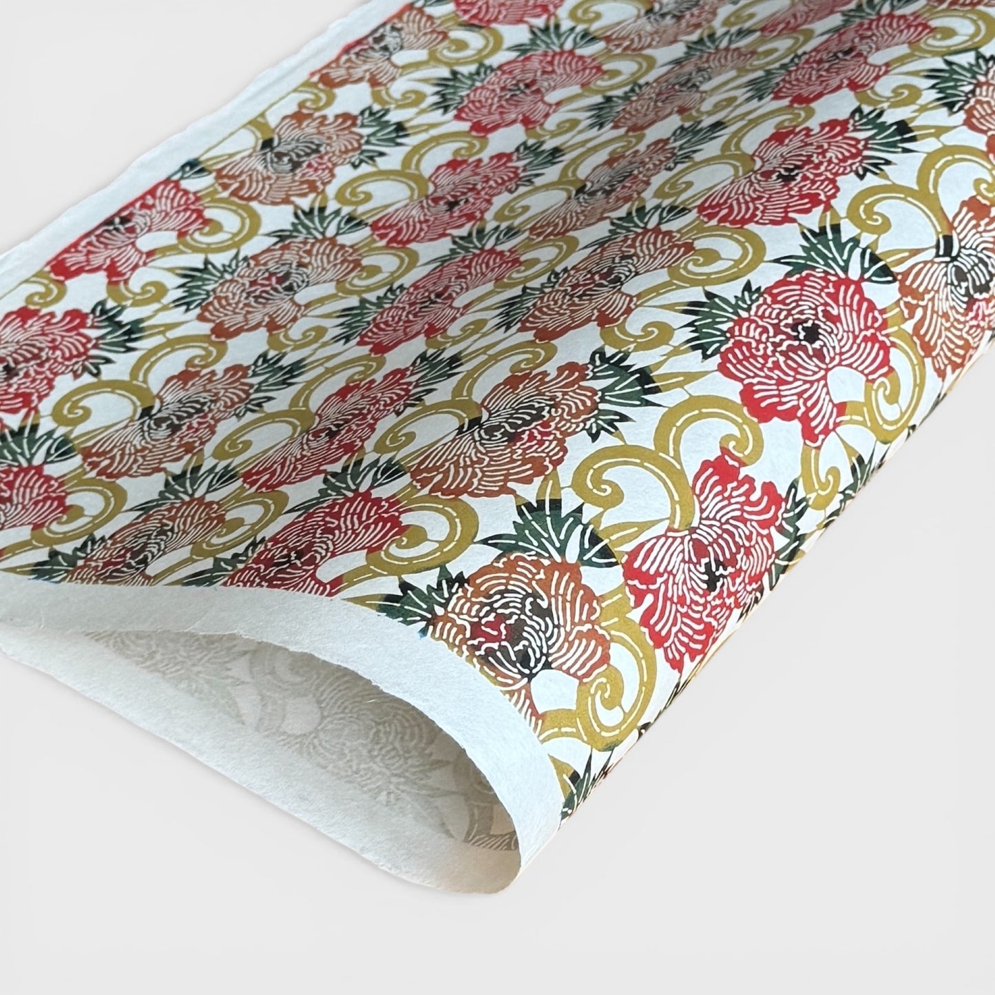 Japanese Katazome-shi stencil-dyed paper with repeat pattern on stylised peonies in autumnal colours.