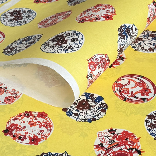 japanese stencil-dyed handmade paper with traditional botanical circles pattern on yellow backdrop