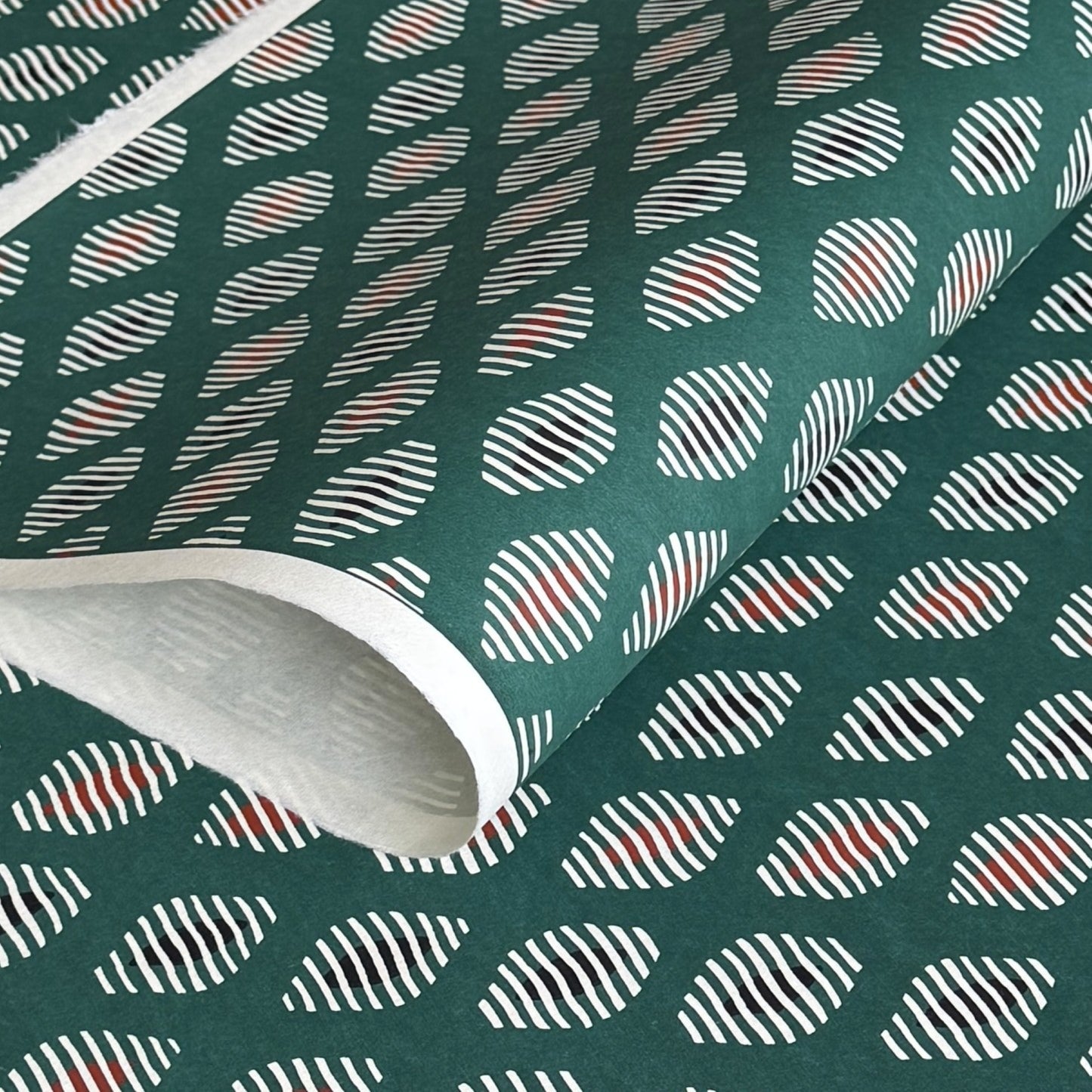 japanese stencil-dyed paper with geometric oval pattern in white, black and red on green background