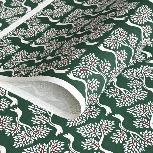 A Japanese stencil-dyed patterned paper in dark green with a repeat pattern of white bonsai trees.