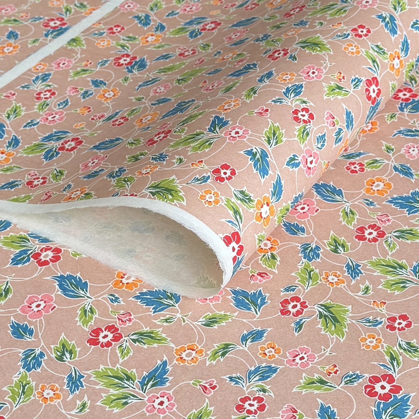 japanese stencil-dyed handmade paper with delicate repeat multi colour floral pattern on blush backdrop