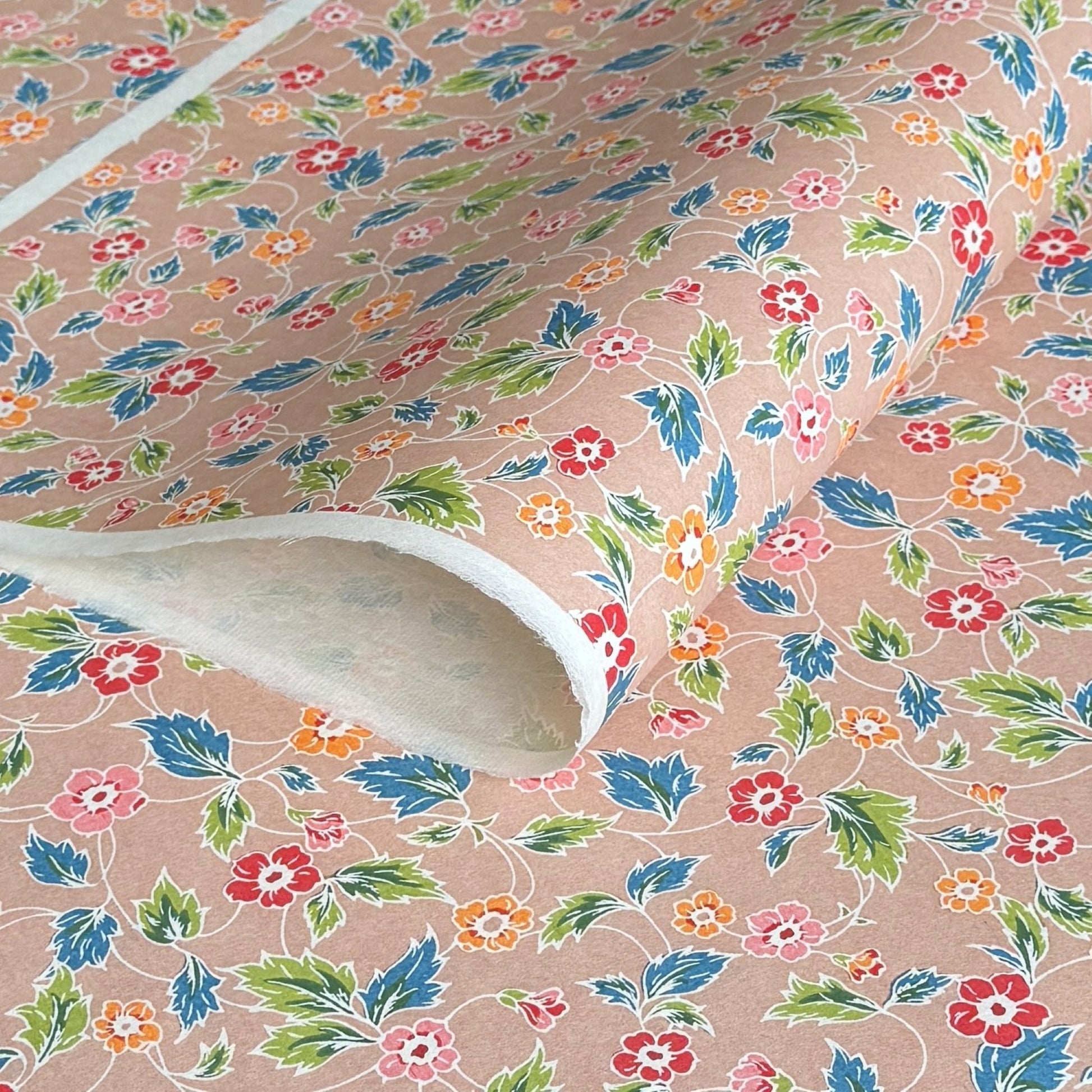japanese stencil-dyed handmade paper with delicate repeat multi colour floral pattern on blush backdrop