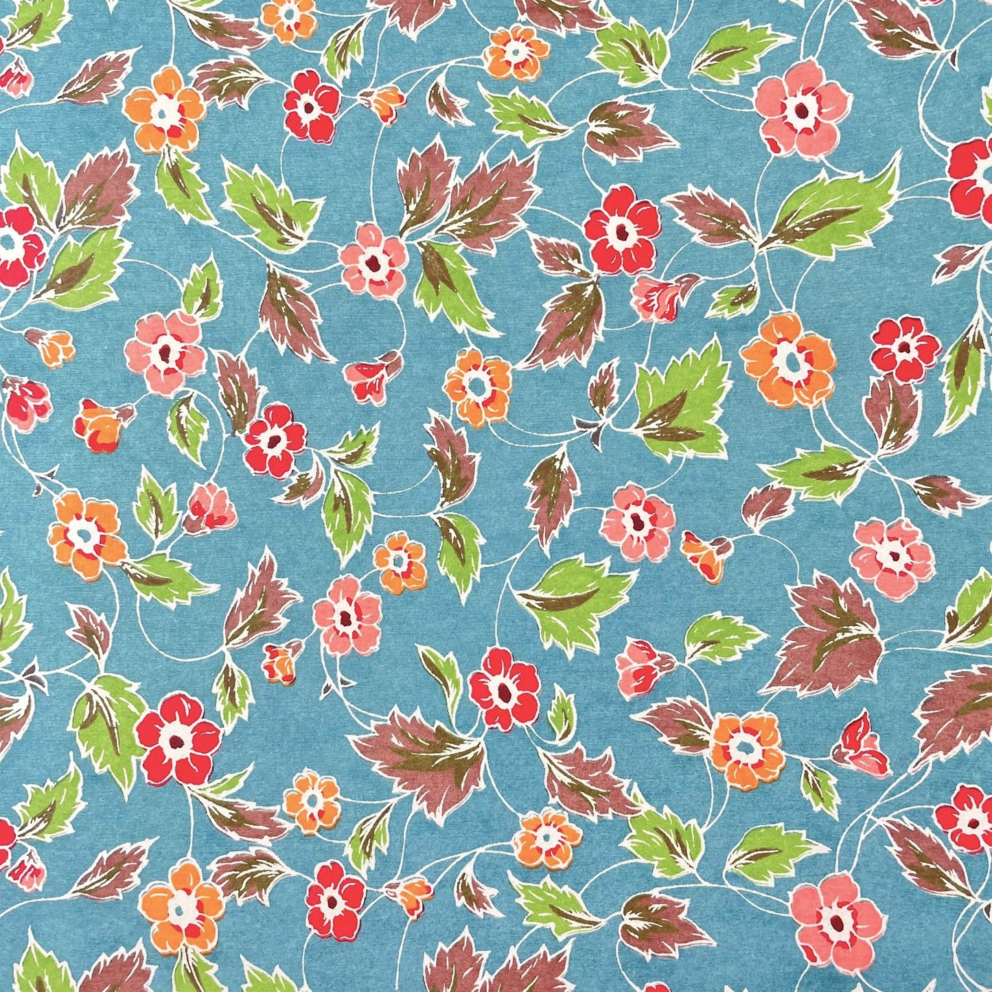 japanese stencil-dyed handmade paper with delicate repeat multi colour floral pattern on blue backdrop