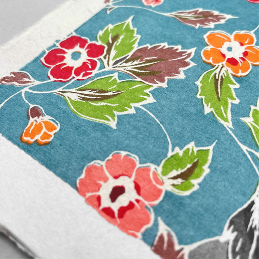 japanese stencil-dyed handmade paper with delicate repeat multi colour floral pattern on blue backdrop