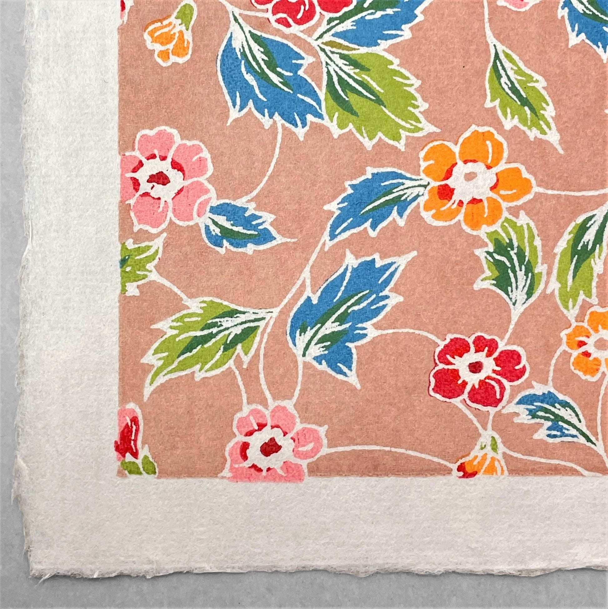 japanese stencil-dyed handmade paper with delicate repeat multi colour floral pattern on blush backdrop