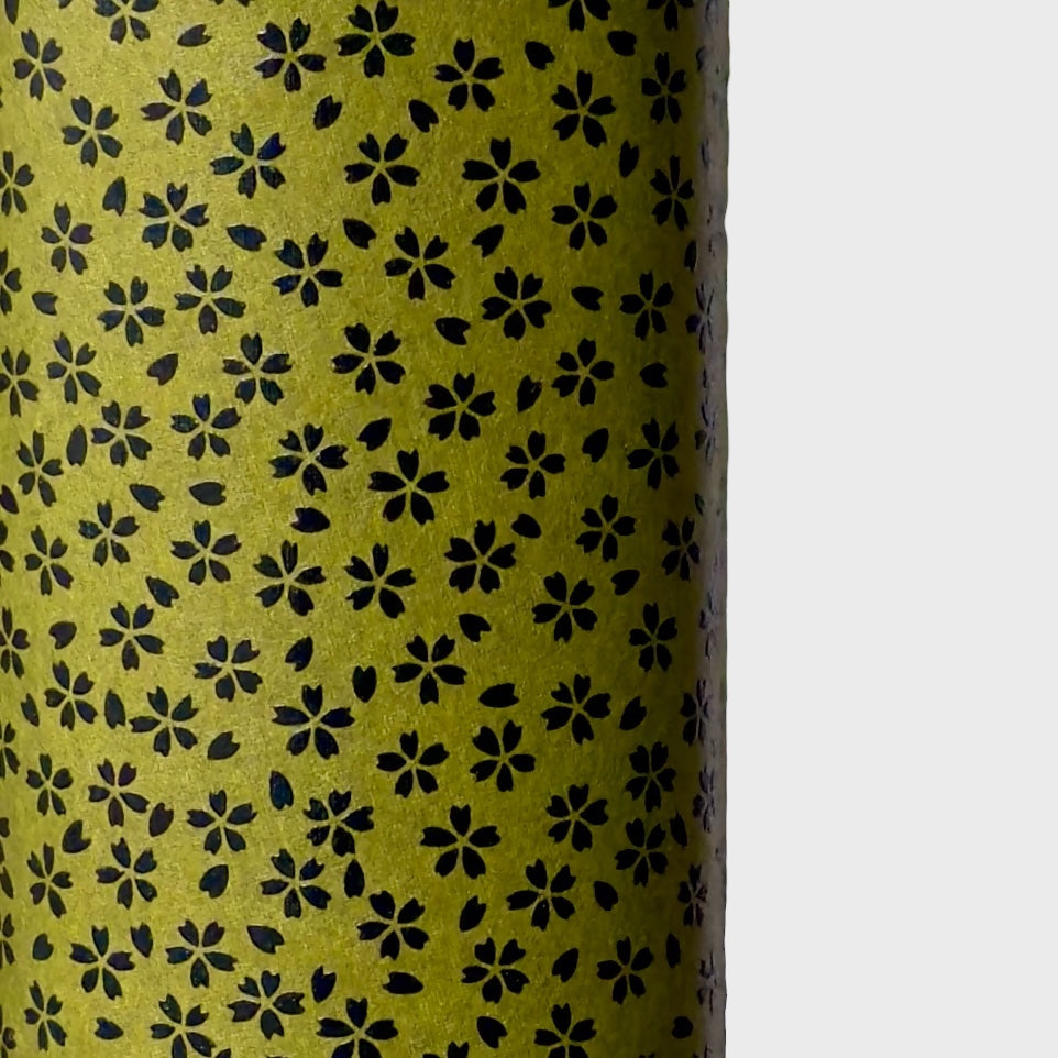A sheet of Japanese lacquered yuzen paper in dark olive green with little cherry blossom flowers in black