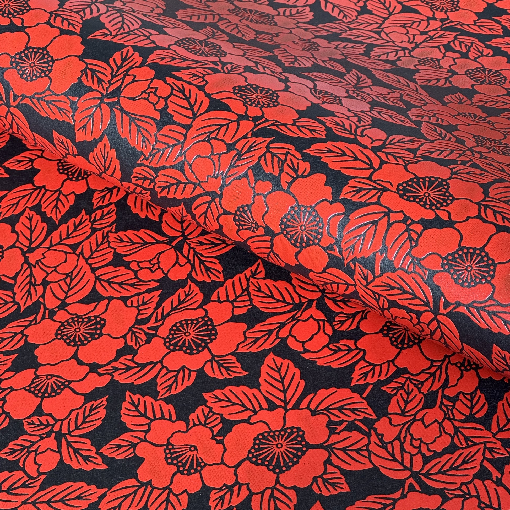 A sheet of Japanese lacquered yuzen paper in black with a red camellia flower pattern